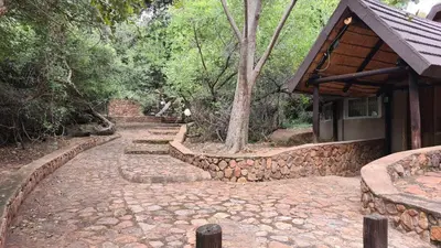 a stone path next to a house with a stone wall at Northwich Game Ranch in Louis Trichardt
