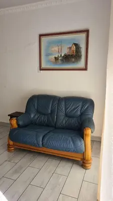 a blue couch sitting in a room with a painting at Northwich Game Ranch in Louis Trichardt