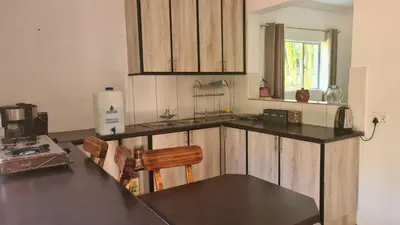 a kitchen with wooden cabinets and a black counter top at Northwich Game Ranch in Louis Trichardt
