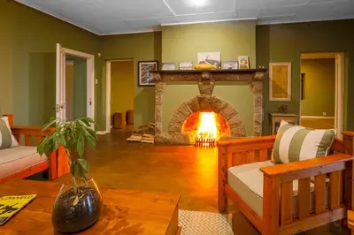 a living room with a fireplace and a couch at The Stone House in Die Winkler