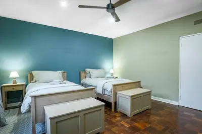 two beds in a room with blue walls at The Stone House in Die Winkler