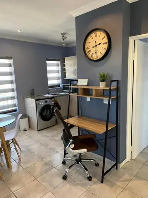 a room with a desk and a clock on the wall at Relaxing Getaway in Waterfall - close to Mall of Africa in Midrand