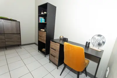 a black desk with a yellow chair in a room at AfricaLove on Tiger in Pretoria