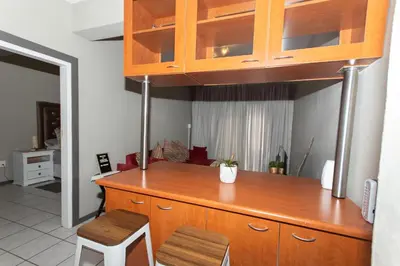 a kitchen with a large wooden counter top with two stools at AfricaLove on Tiger in Pretoria