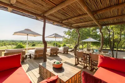 an outdoor patio with tables and chairs and umbrellas at Baobab Ridge in Klaserie Private Nature Reserve