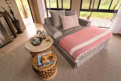 a bedroom with a bed and a couch and a table at Baobab Ridge in Klaserie Private Nature Reserve