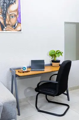 a desk with a laptop and a chair in a room at Mills Pad with 2-bedroom in Nelspruit