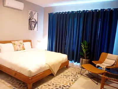 a bedroom with a bed and blue curtains at Mills Pad with 2-bedroom in Nelspruit