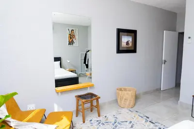 a living room with a bed and a mirror at Mills Pad with 2-bedroom in Nelspruit