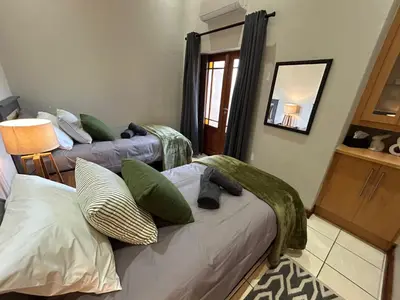 a room with two beds and a mirror at Fish Eagle Bay 28, Warmbaths in Bela-Bela