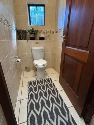 a bathroom with a toilet and a black and white rug at Fish Eagle Bay 28, Warmbaths in Bela-Bela