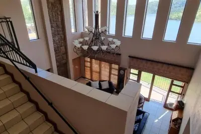 a staircase in a house with a chandelier at Fish Eagle Bay 28, Warmbaths in Bela-Bela