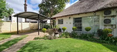 a house with a thatched roof and a yard at Tenuta Overnight in Polokwane