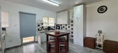a kitchen with a table and a clock on the wall at Tenuta Overnight in Polokwane