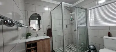 a bathroom with a shower and a sink and a mirror at Tenuta Overnight in Polokwane