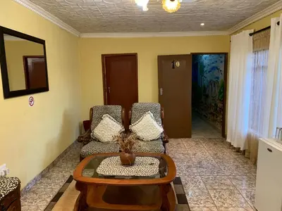 a living room with two chairs and a table at Sikhula Sonke Guest House in Erasmus