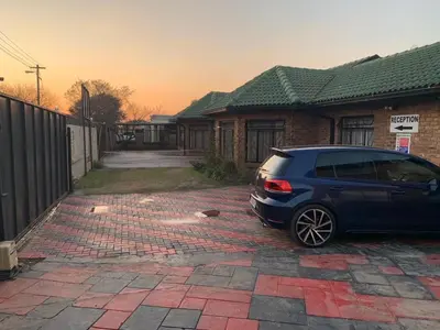 a blue car parked in front of a house at Sikhula Sonke Guest House in Erasmus