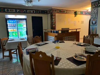 a dining room with a table with a white table cloth at Sikhula Sonke Guest House in Erasmus
