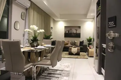 a living room with a dining table and a couch at Menlyn Maine High Rise 1-Bedroom Luxury Apartment in Pretoria