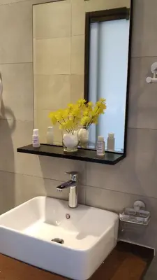 a bathroom sink with yellow flowers in a mirror at Palm View Midrand Guest House in Midrand