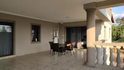 a dining room with a table and chairs at Palm View Midrand Guest House in Midrand