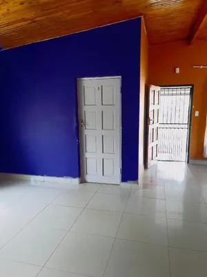 an empty room with a blue wall and a door at Galaxy Guest House Pretoria in Pretoria