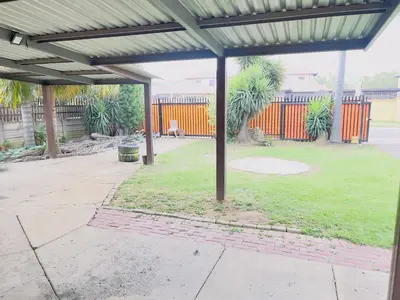 a patio with awning in a yard with a park at Galaxy Guest House Pretoria in Pretoria