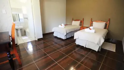 a room with two beds and a bathroom at Jock-Sabie Lodge in Sabie