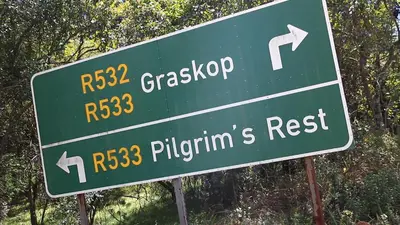 a green street sign with directions to the freeway at Jock-Sabie Lodge in Sabie
