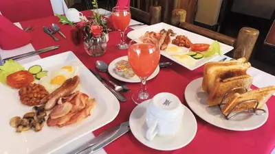 a table with plates of food on a red table at Jock-Sabie Lodge in Sabie