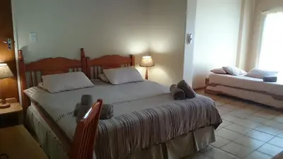 a bedroom with a large bed and a couch at Jock-Sabie Lodge in Sabie