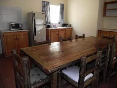 a kitchen with a wooden table and a refrigerator at Jock-Sabie Lodge in Sabie