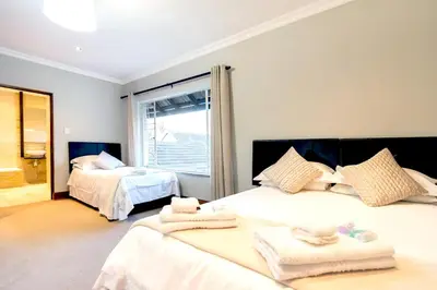 a bedroom with two beds with towels on them at OR Tambo Guest House in Kempton Park