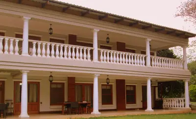 a large white house with a balcony on top at OR Tambo Guest House in Kempton Park