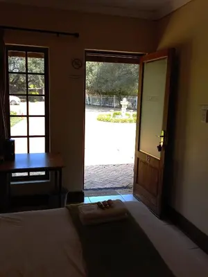 a bedroom with a bed and a door to a courtyard at OR Tambo Guest House in Kempton Park