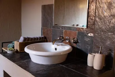 a bathroom with a white sink and a mirror at Larima Bush Retreat in Hoedspruit