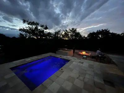 a person sitting at a table next to a blue pool at Larima Bush Retreat in Hoedspruit