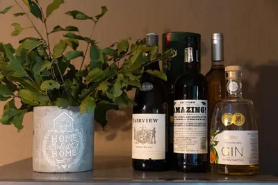 four bottles of wine and a potted plant on a shelf at Larima Bush Retreat in Hoedspruit