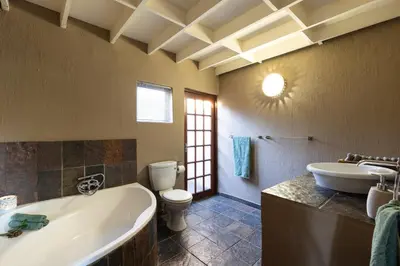 a bathroom with a tub and a toilet and a sink at Larima Bush Retreat in Hoedspruit