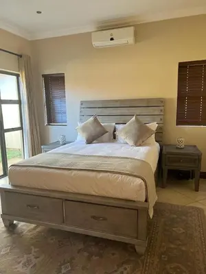 a bedroom with a large bed with white sheets and pillows at Pecanwood Dam View in Hartbeespoort