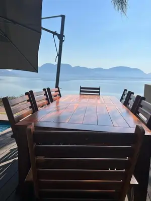 a wooden table with two chairs and an umbrella at Pecanwood Dam View in Hartbeespoort