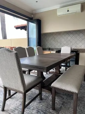 a wooden table and chairs in a room at Pecanwood Dam View in Hartbeespoort