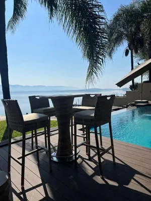 a table and chairs sitting next to a swimming pool at Pecanwood Dam View in Hartbeespoort