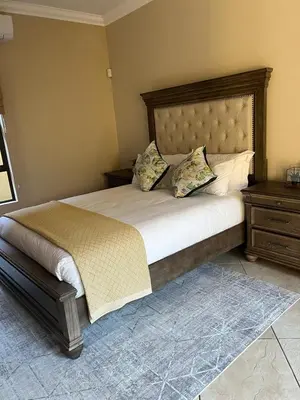 a bedroom with a large bed with a wooden headboard at Pecanwood Dam View in Hartbeespoort