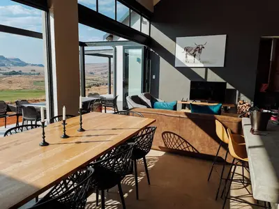 a living room with a wooden table and chairs at The Big Easy Rest at Highland Gate Golf & Trout in Dullstroom