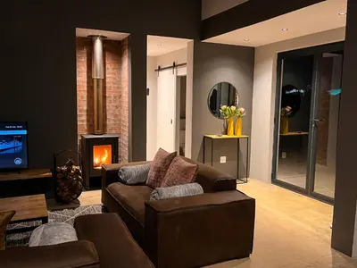 a living room with a couch and a fireplace at The Big Easy Rest at Highland Gate Golf & Trout in Dullstroom