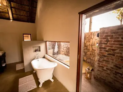 a bathroom with a large window and a bath tub at Bushwa Private Game Lodge in Vaalwater
