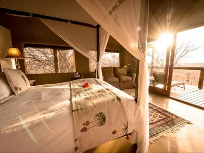 a bedroom with a large bed with a canopy at Bushwa Private Game Lodge in Vaalwater