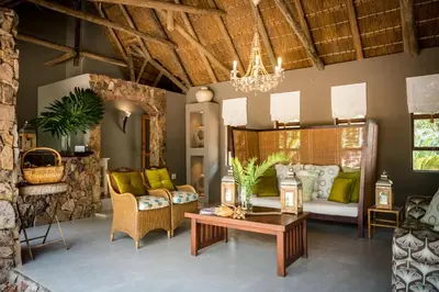 a living room with a couch and a table at Bushwa Private Game Lodge in Vaalwater