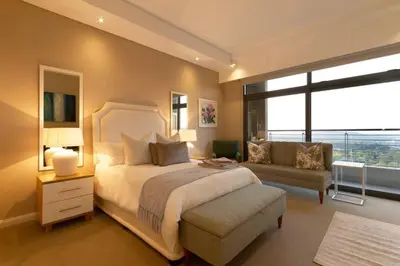 a bedroom with a bed and a couch and a window at Alimama Spaces: Koketso's Menlyn Maine in Pretoria